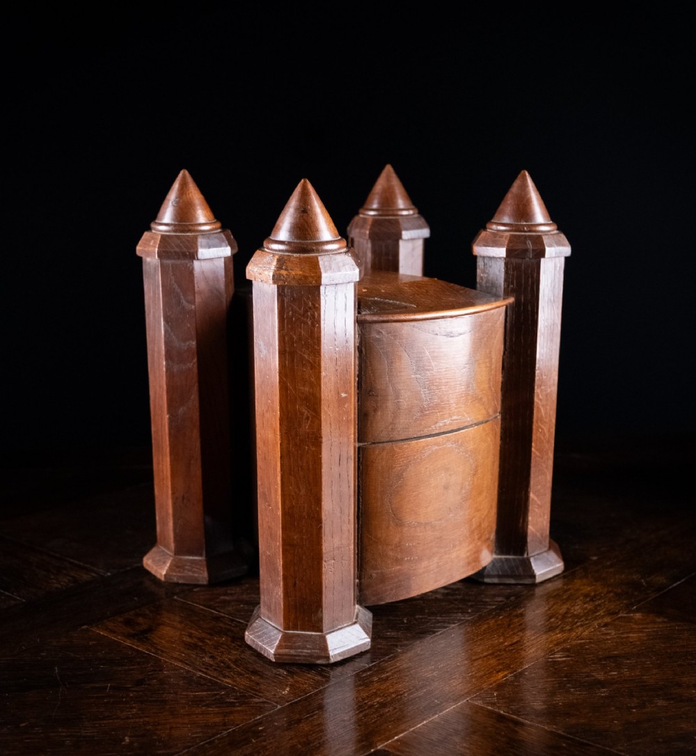 A 19th-century carved oak jewellery box designed like a castle with four corner turrets, floral relief panels, and small drawers. View XIII