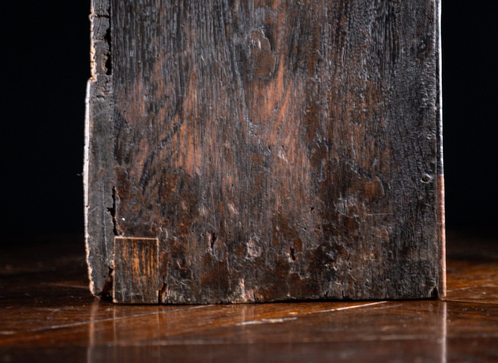 An 18th-century dark oak tabletop chest of drawers featuring seven multi-sized drawers with brass knob handles and a brass keyhole escutcheon. View X