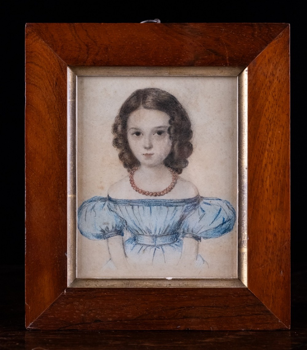 An early 19th-century watercolour portrait miniature depicting a young girl with dark curls in a blue dress, displayed in a dark wood frame.