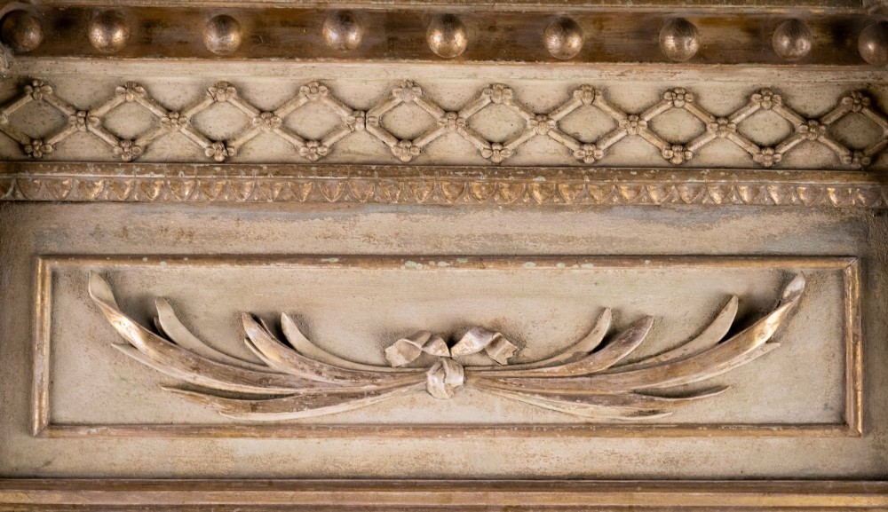 A tall Regency painted and gilded pier mirror featuring fluted columns, lion mask capitals, a carved bow swag frieze, and a ball cornice. View IV