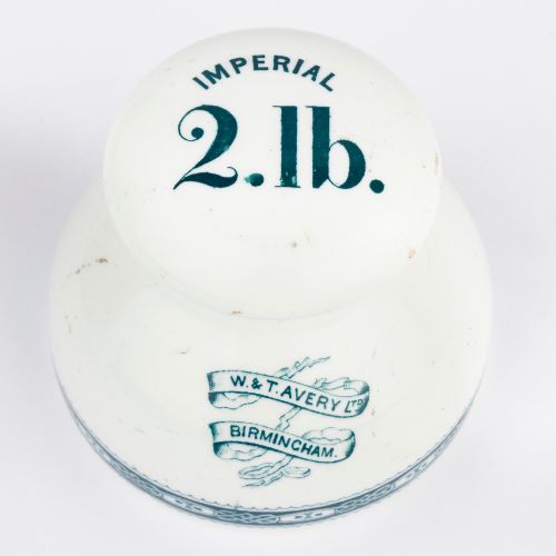 fig 1. A pair of white glazed ceramic shop scale weights decorated with blue transfer-printed text and scroll borders for W and T Avery Birmingham.