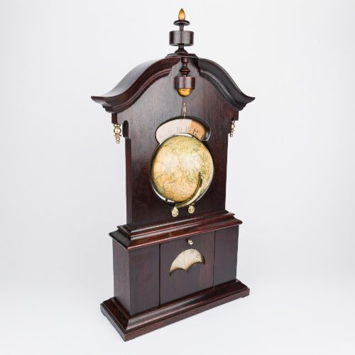 fig 1. A dark mahogany Timby solar timepiece featuring an embedded central globe beneath a curved hour scale and brass finials.