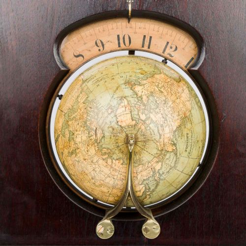 fig 3. A dark mahogany Timby solar timepiece featuring an embedded central globe beneath a curved hour scale and brass finials.