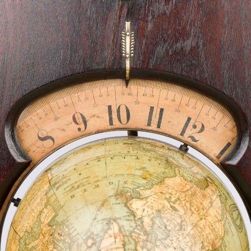 fig 4. A dark mahogany Timby solar timepiece featuring an embedded central globe beneath a curved hour scale and brass finials.