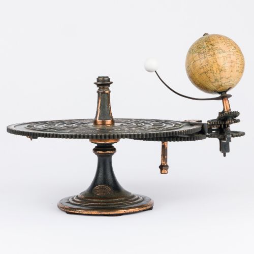 fig 1. A Victorian Parkes and Hadley patent tellurian orrery featuring a cast metal base with calendar markings, interlocking gears, and a small terrestrial globe with a moon attachment.