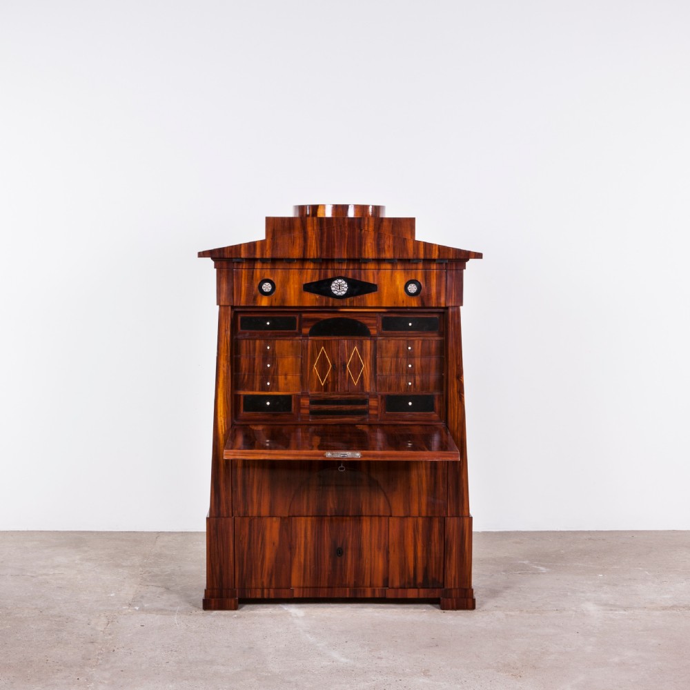 A tall Biedermeier secretaire a abattant featuring rich bookmatched brown wood veneers, an architectural pediment top, a fall-front desk section, and lower drawers with ebonised detail. View III