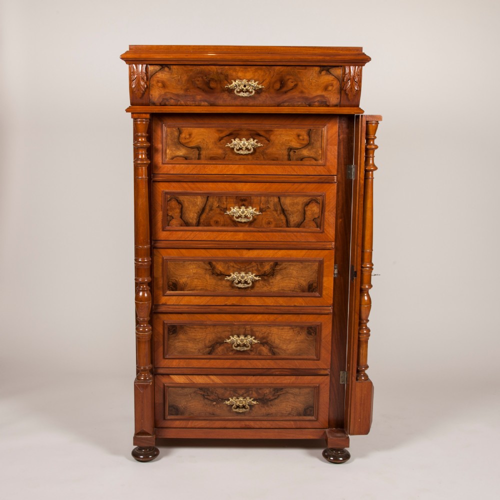 A tall 19th-century burr walnut chest of six drawers featuring ornate gilded brass handles, flanking turned pilasters, and bun feet. View II