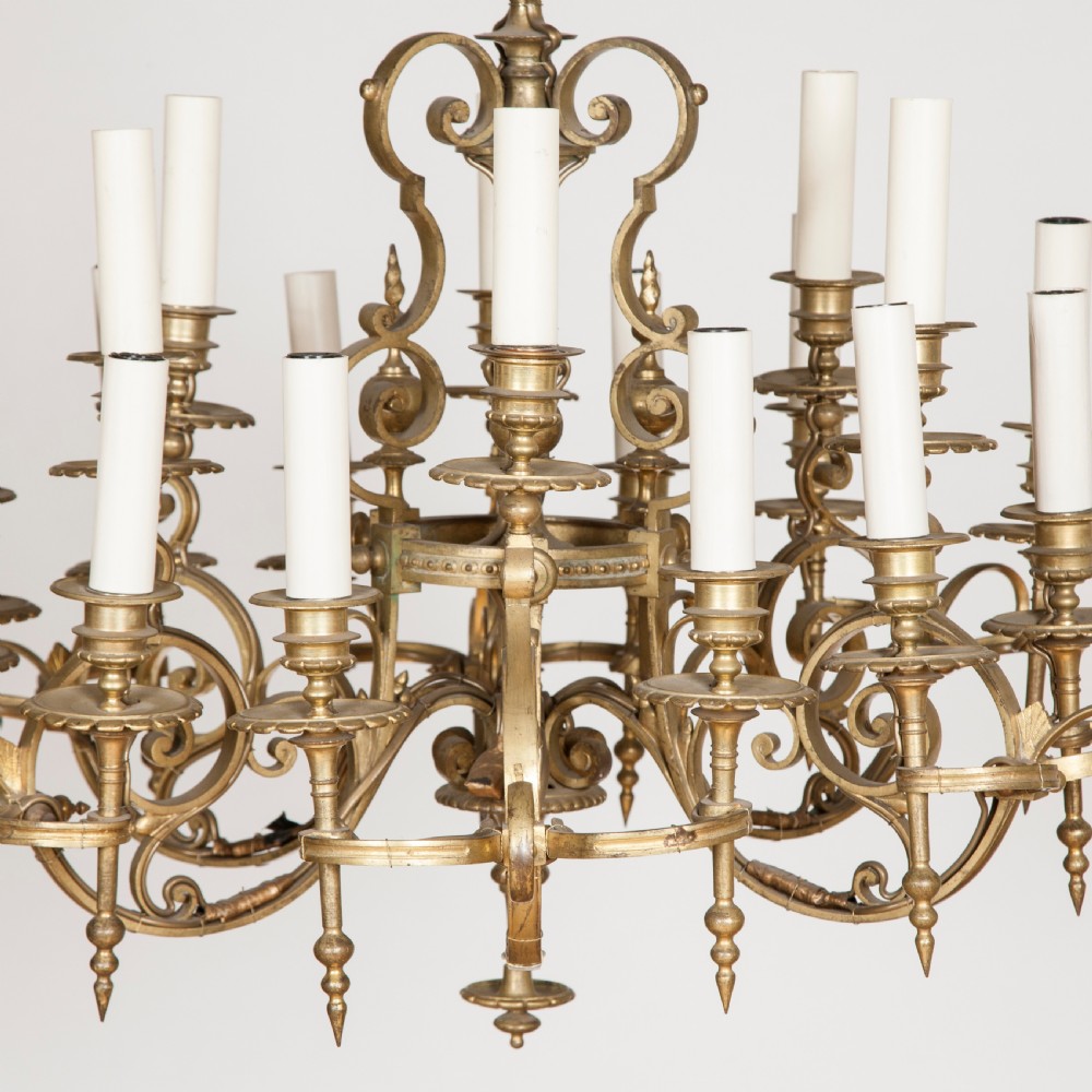 A late nineteenth-century gilt bronze eighteen-light chandelier featuring tiered scrollwork arms and faux candle sleeves. View II