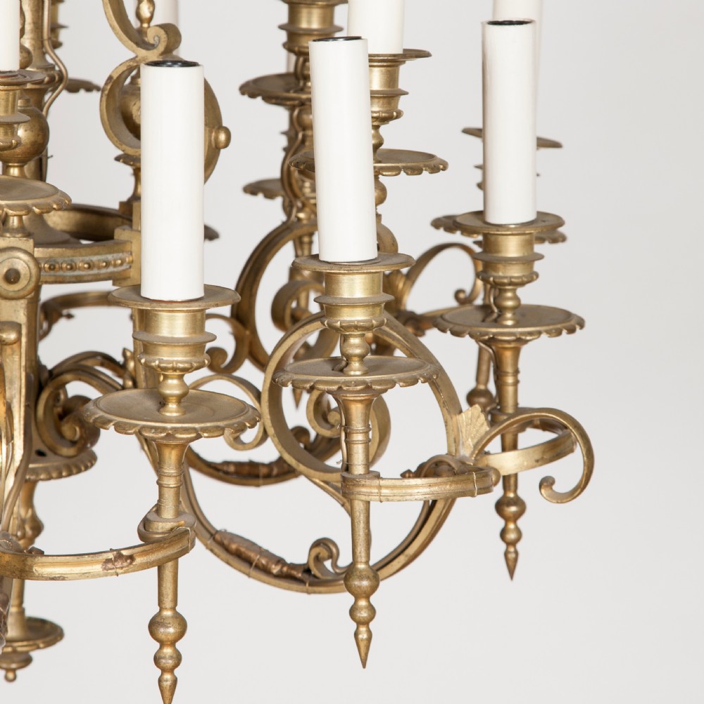 A late nineteenth-century gilt bronze eighteen-light chandelier featuring tiered scrollwork arms and faux candle sleeves. View III