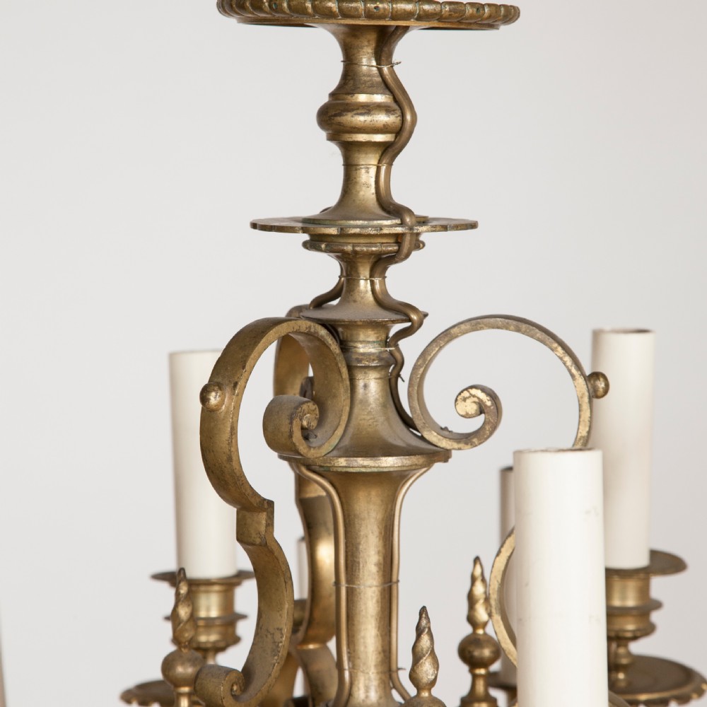 A late nineteenth-century gilt bronze eighteen-light chandelier featuring tiered scrollwork arms and faux candle sleeves. View IV