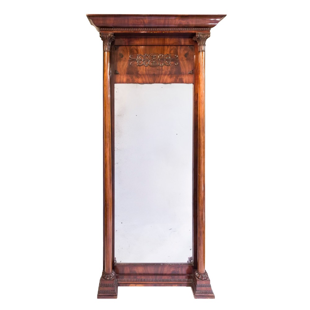 A tall rectangular mahogany pier mirror featuring carved classical columns, flame veneer upper frieze with carved scroll details, and a moulded cornice top.