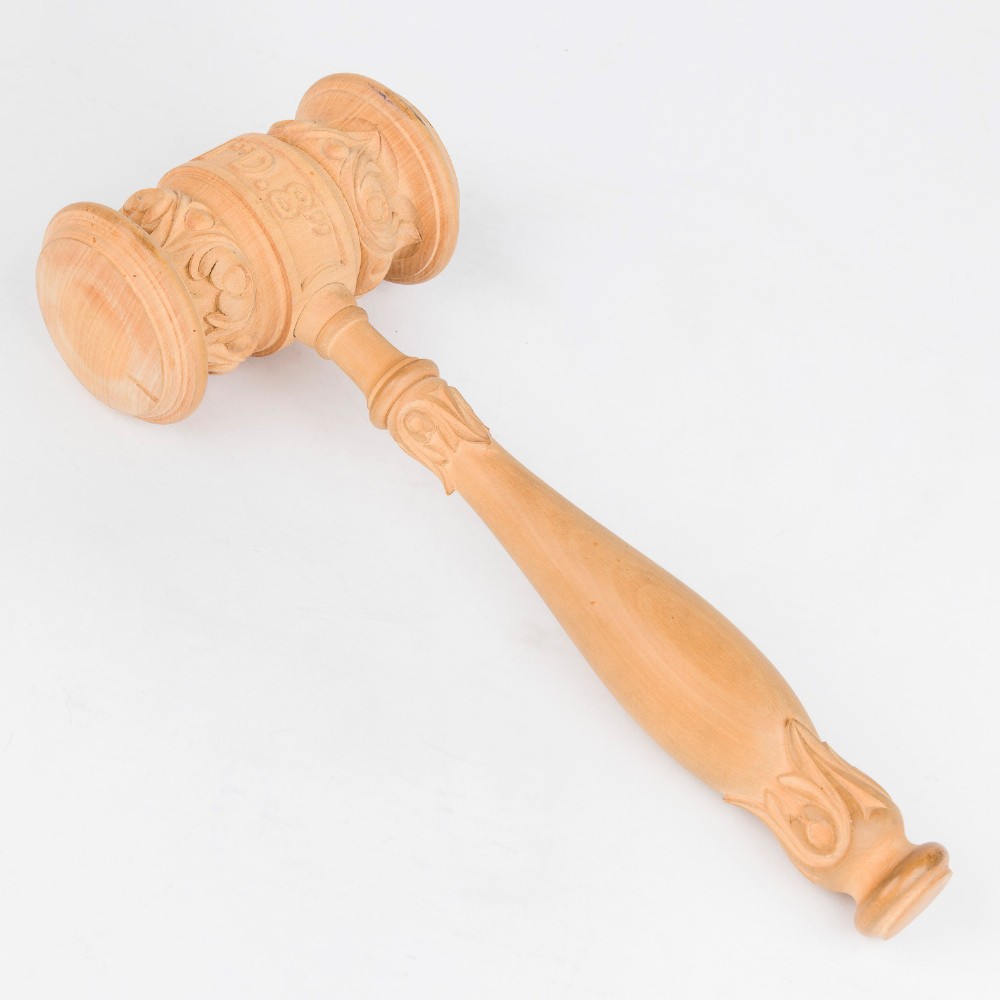 An open Edwardian carved oak presentation casket lined in navy blue velvet, containing a carved wooden ceremonial mallet and chisel set with an engraved silver plaque. View V