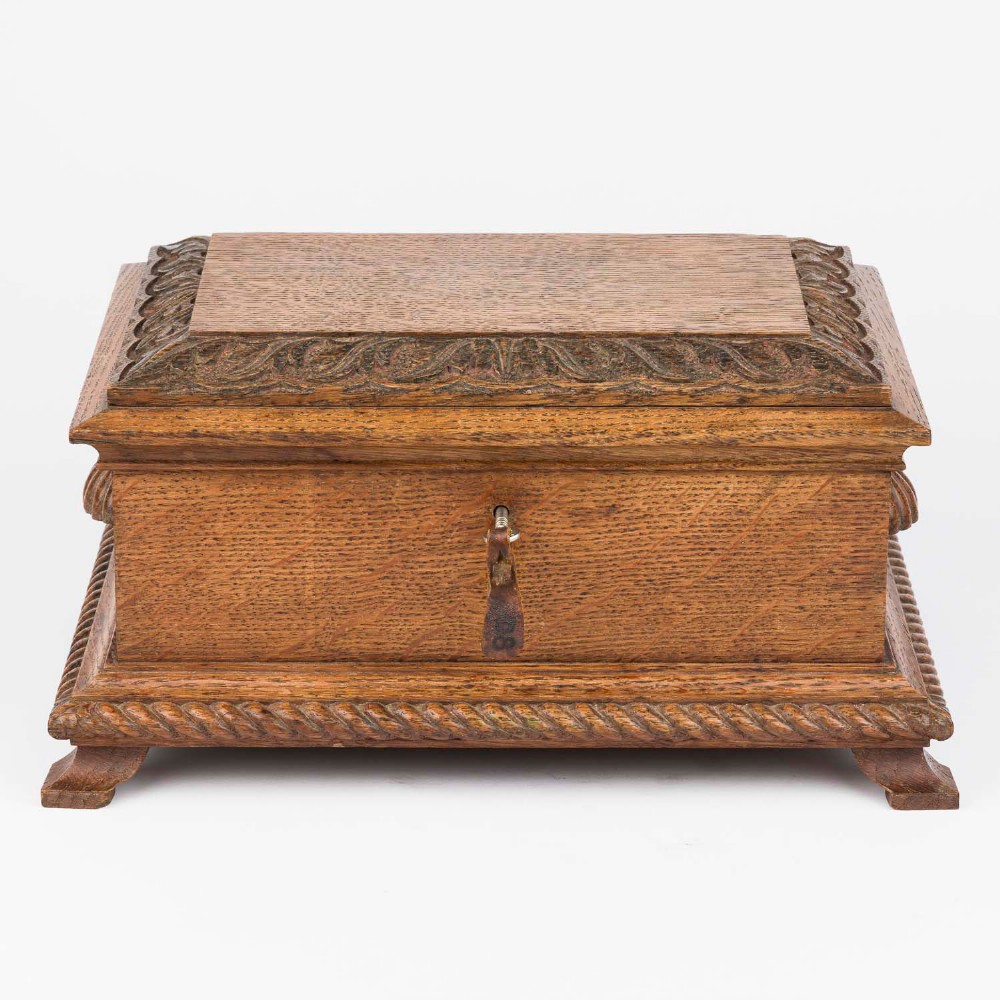 An open Edwardian carved oak presentation casket lined in navy blue velvet, containing a carved wooden ceremonial mallet and chisel set with an engraved silver plaque. View XIV