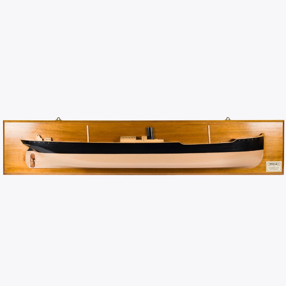 A half hull ship model of the S.S. Othello painted black and cream mounted horizontally on a rectangular mahogany backboard with a metal builder plaque.