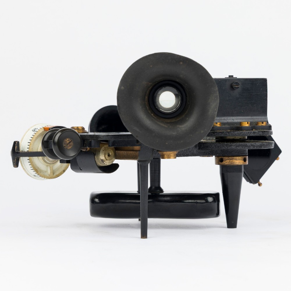 A mid-20th-century black metal and brass RAF bubble sextant with optical lenses, fine adjustment dials, and an engraved Air Ministry stamp. View IV