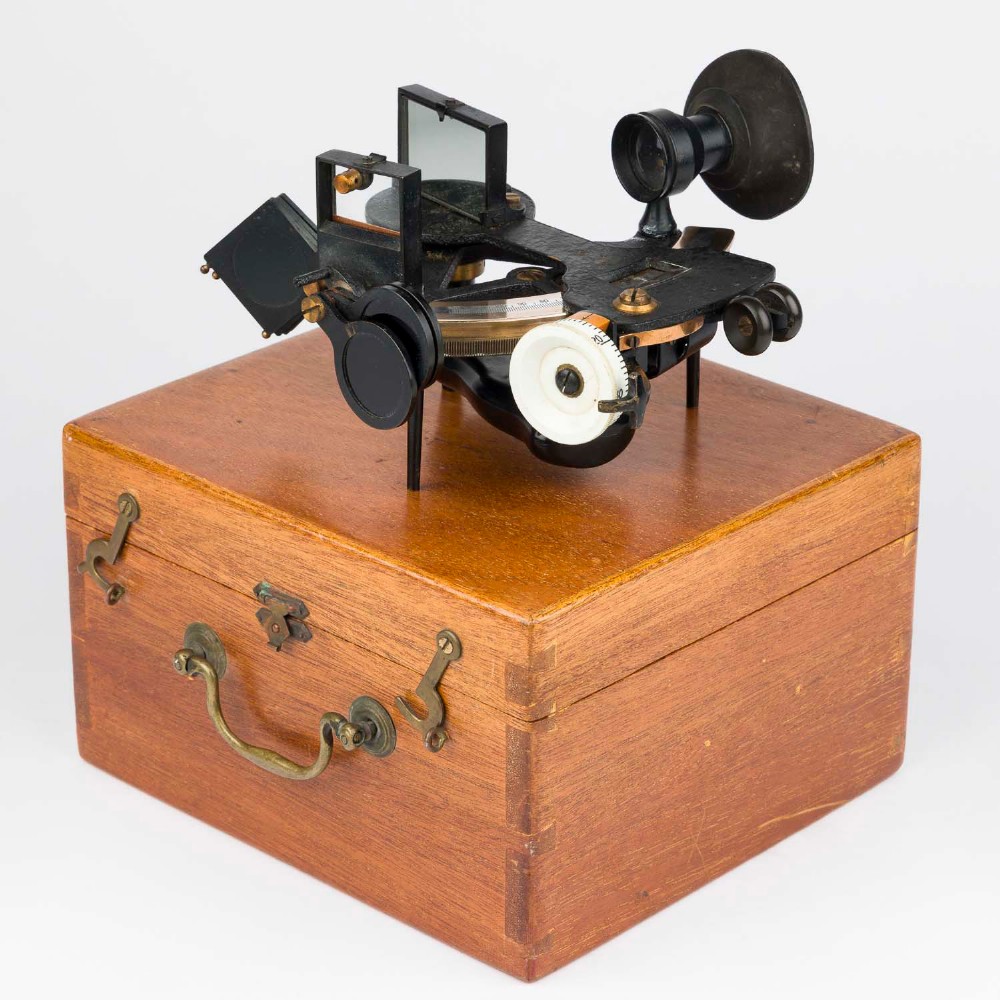 A mid-20th-century black metal and brass RAF bubble sextant with optical lenses, fine adjustment dials, and an engraved Air Ministry stamp. View VI