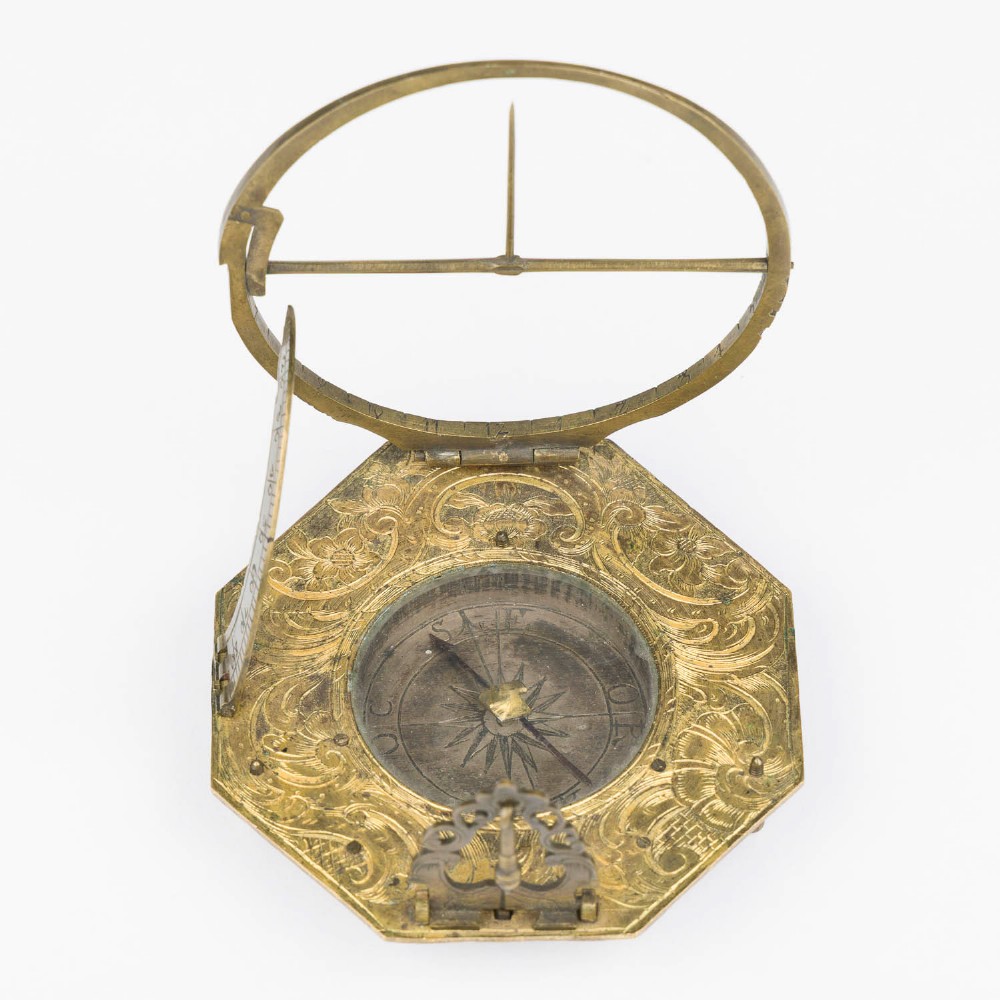 An 18th-century engraved brass octagonal pocket sundial with an inset glass-covered compass, an adjustable latitude arc, and a hinged hour ring. View IV