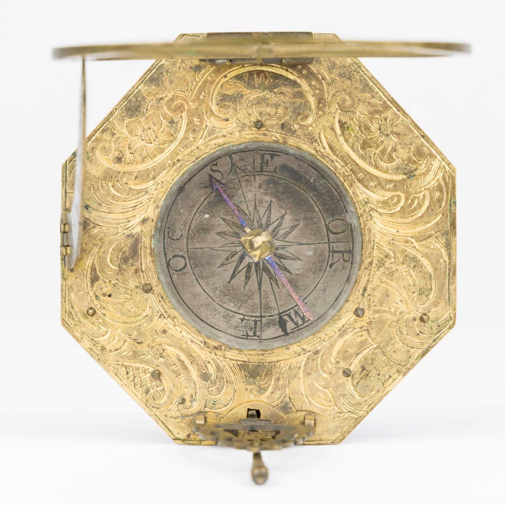 An 18th-century engraved brass octagonal pocket sundial with an inset glass-covered compass, an adjustable latitude arc, and a hinged hour ring. View V