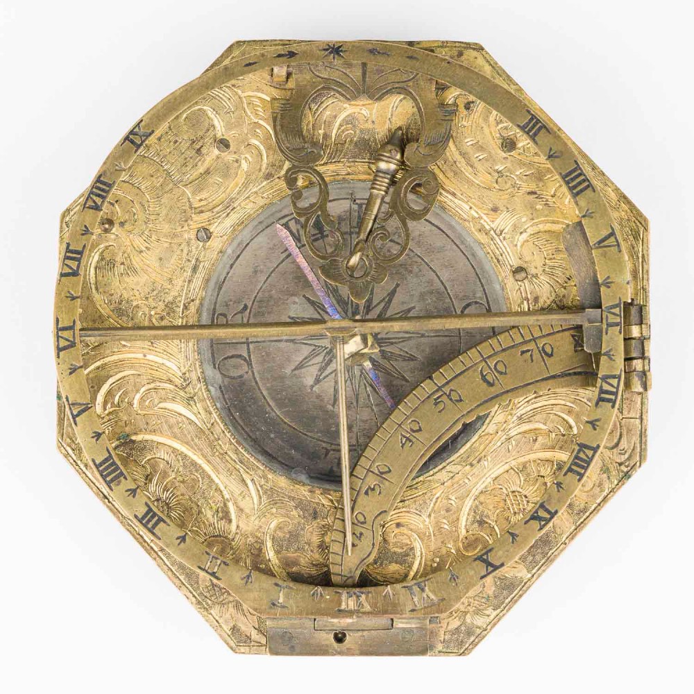 An 18th-century engraved brass octagonal pocket sundial with an inset glass-covered compass, an adjustable latitude arc, and a hinged hour ring. View VI