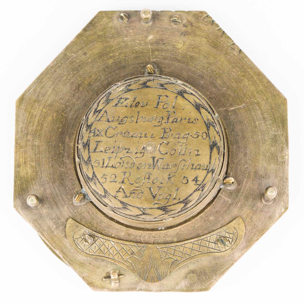An 18th-century engraved brass octagonal pocket sundial with an inset glass-covered compass, an adjustable latitude arc, and a hinged hour ring. View VII