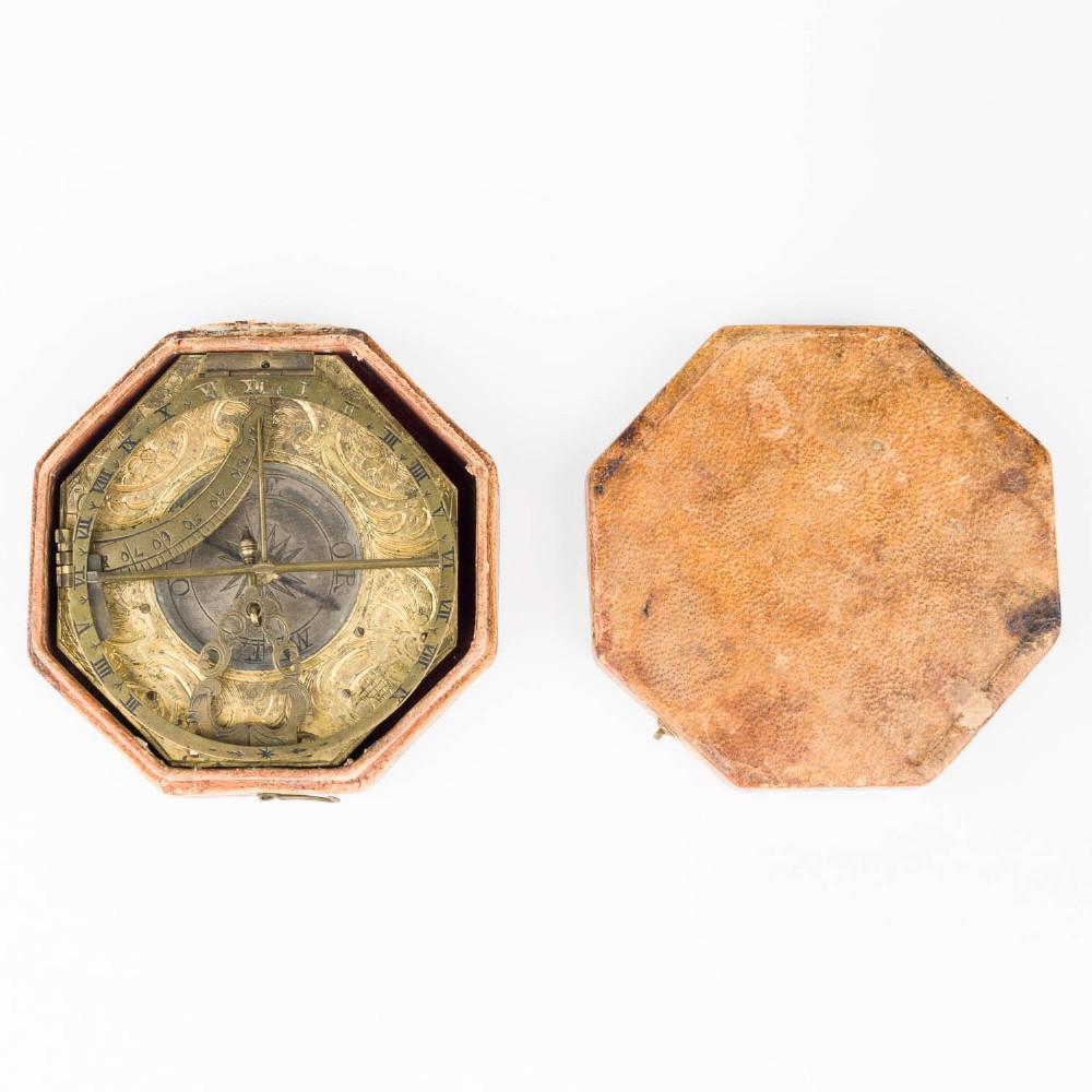 An 18th-century engraved brass octagonal pocket sundial with an inset glass-covered compass, an adjustable latitude arc, and a hinged hour ring. View X
