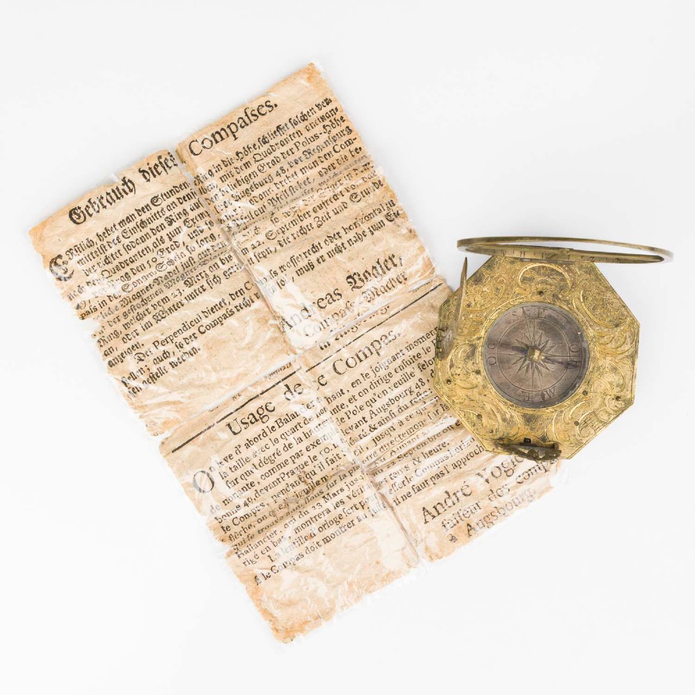 An 18th-century engraved brass octagonal pocket sundial with an inset glass-covered compass, an adjustable latitude arc, and a hinged hour ring. View XIV
