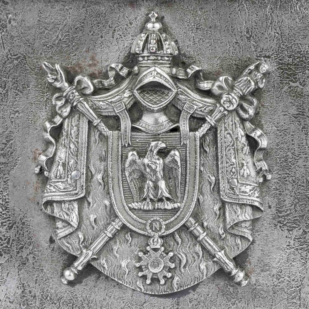 A heavy rectangular metal strongbox featuring riveted steel straps, raised studs, an embossed coat of arms, and maker plaques. View VIII