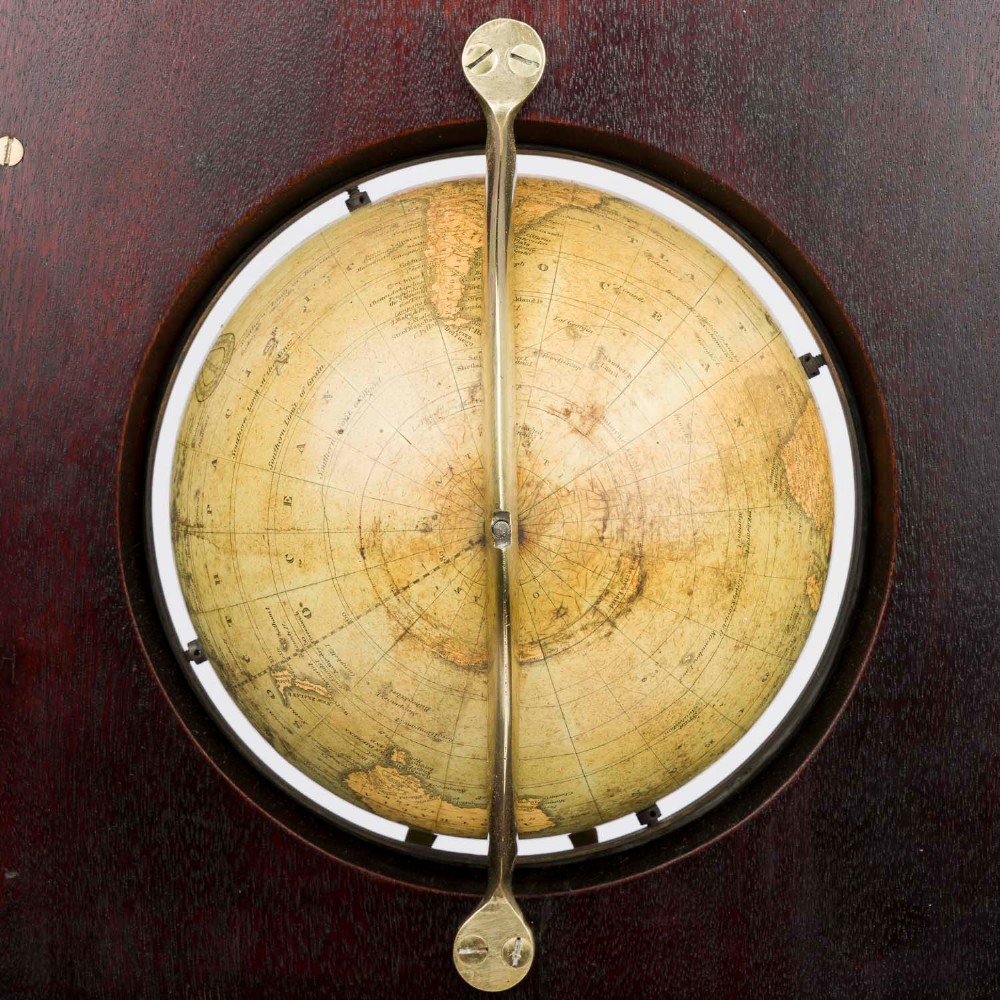 A dark mahogany Timby solar timepiece featuring an embedded central globe beneath a curved hour scale and brass finials. View IX