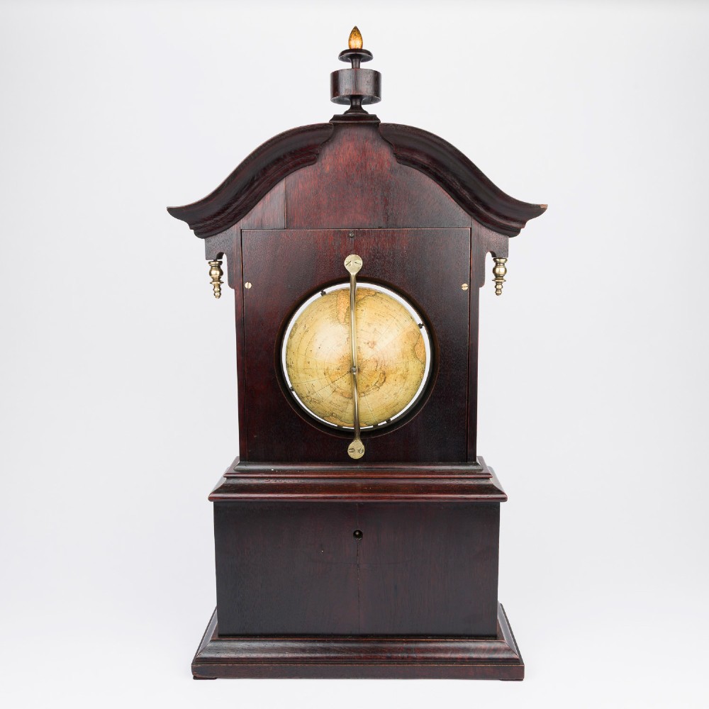 A dark mahogany Timby solar timepiece featuring an embedded central globe beneath a curved hour scale and brass finials. View X