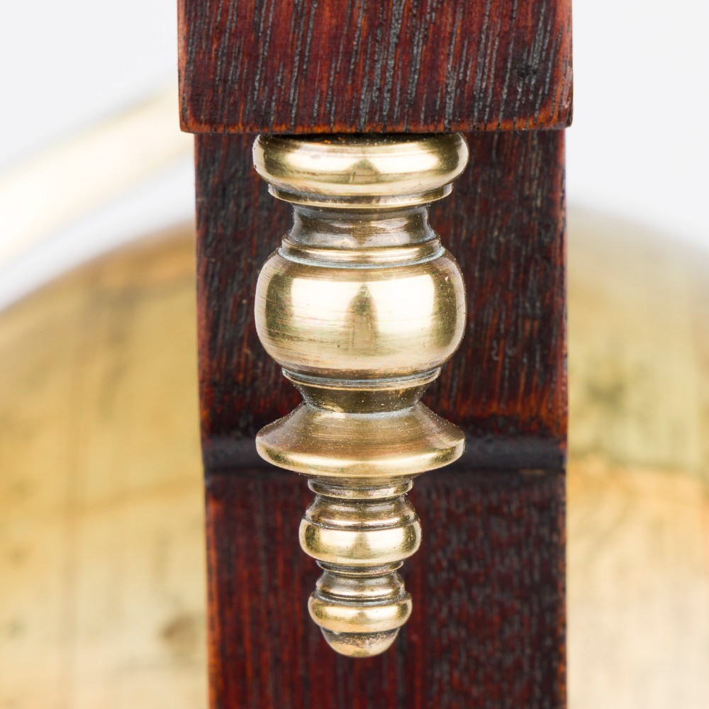 A dark mahogany Timby solar timepiece featuring an embedded central globe beneath a curved hour scale and brass finials. View XII