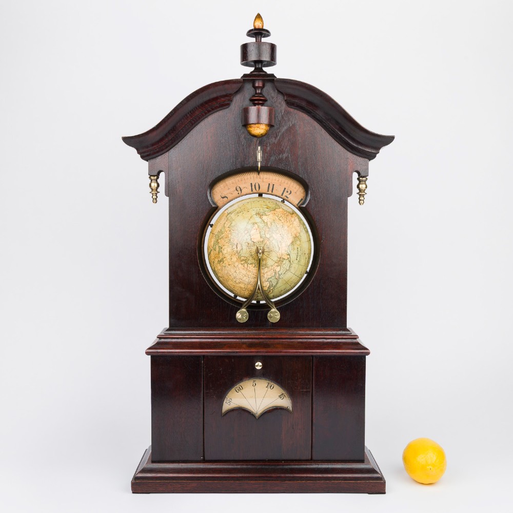 A dark mahogany Timby solar timepiece featuring an embedded central globe beneath a curved hour scale and brass finials. View XIV