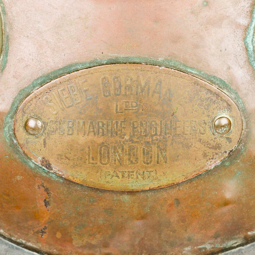 An antique Siebe Gorman copper and brass deep-sea diving helmet with a central circular viewport and lateral window grilles. View VIII