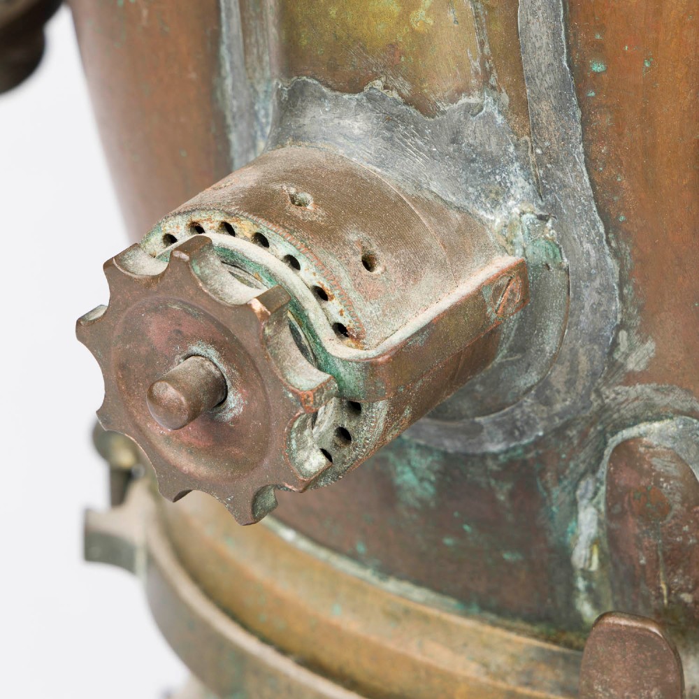 An antique Siebe Gorman copper and brass deep-sea diving helmet with a central circular viewport and lateral window grilles. View XI