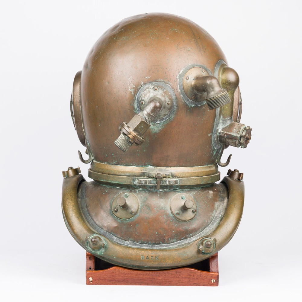 An antique Siebe Gorman copper and brass deep-sea diving helmet with a central circular viewport and lateral window grilles. View XV