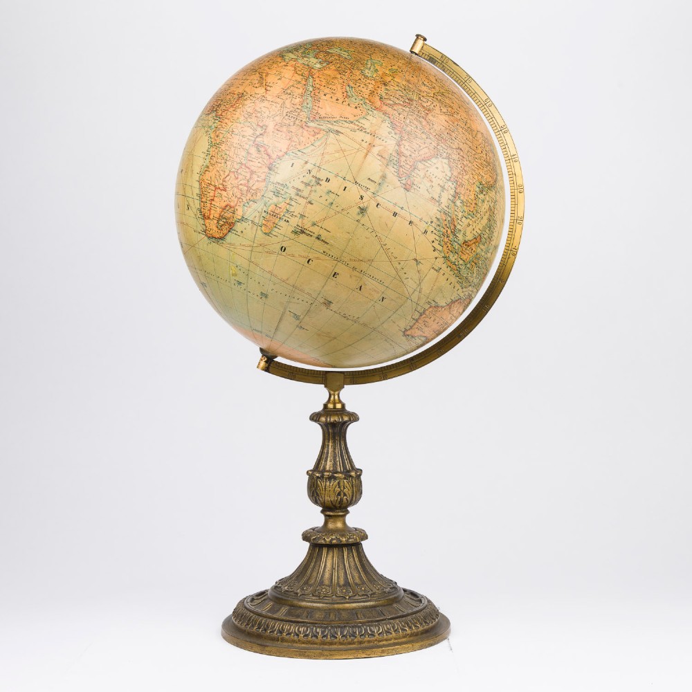 An antique terrestrial globe featuring paper printed maps mounted on a brass half-meridian ring and supported by a cast brass baluster stem base. View IX