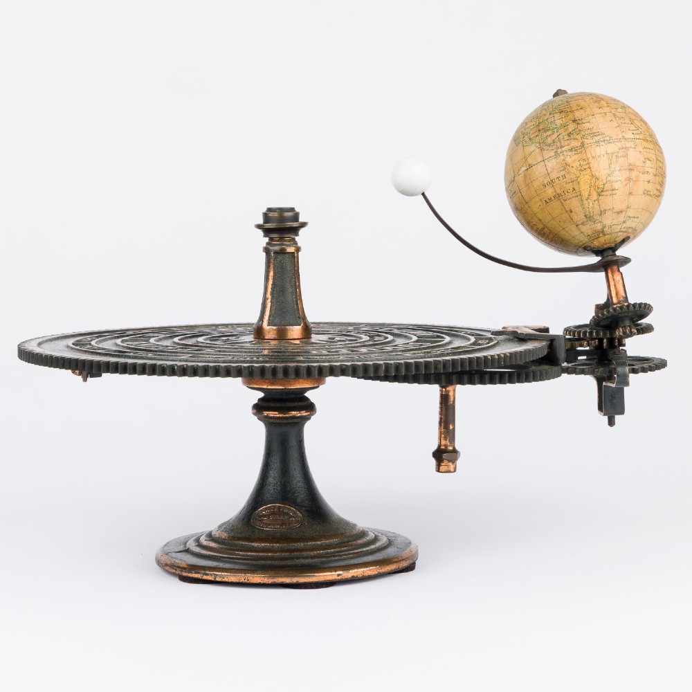 A Victorian Parkes and Hadley patent tellurian orrery featuring a cast metal base with calendar markings, interlocking gears, and a small terrestrial globe with a moon attachment. View II