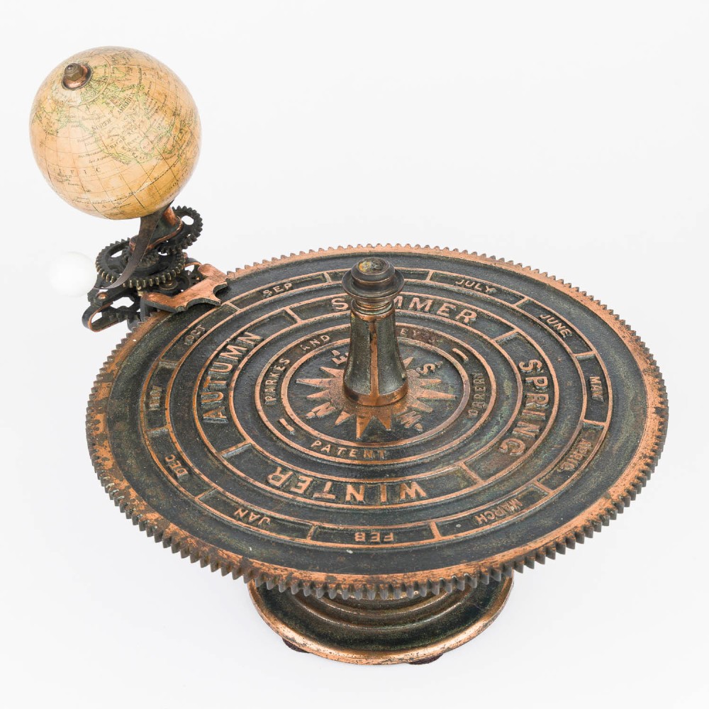 A Victorian Parkes and Hadley patent tellurian orrery featuring a cast metal base with calendar markings, interlocking gears, and a small terrestrial globe with a moon attachment. View IV