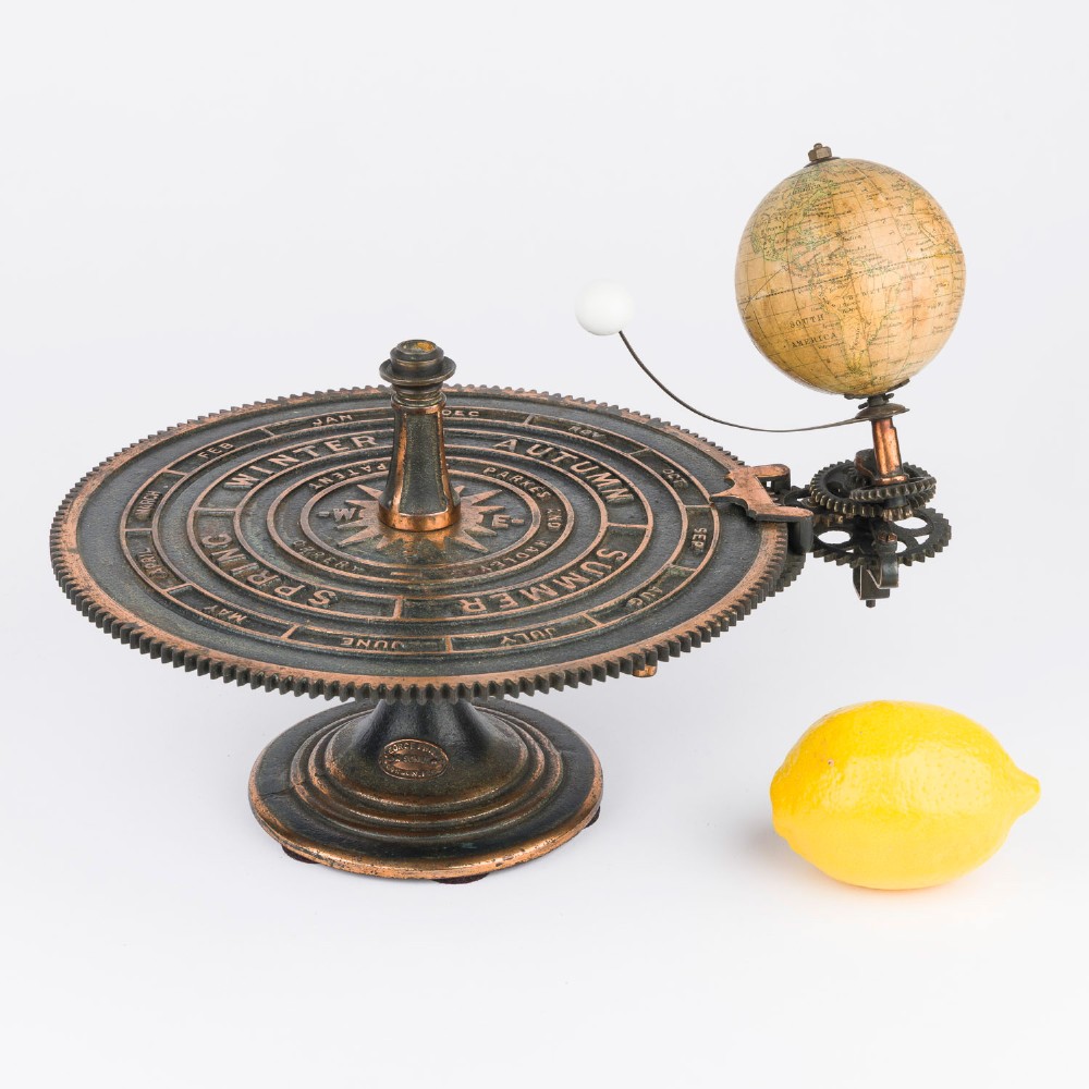 A Victorian Parkes and Hadley patent tellurian orrery featuring a cast metal base with calendar markings, interlocking gears, and a small terrestrial globe with a moon attachment. View XV
