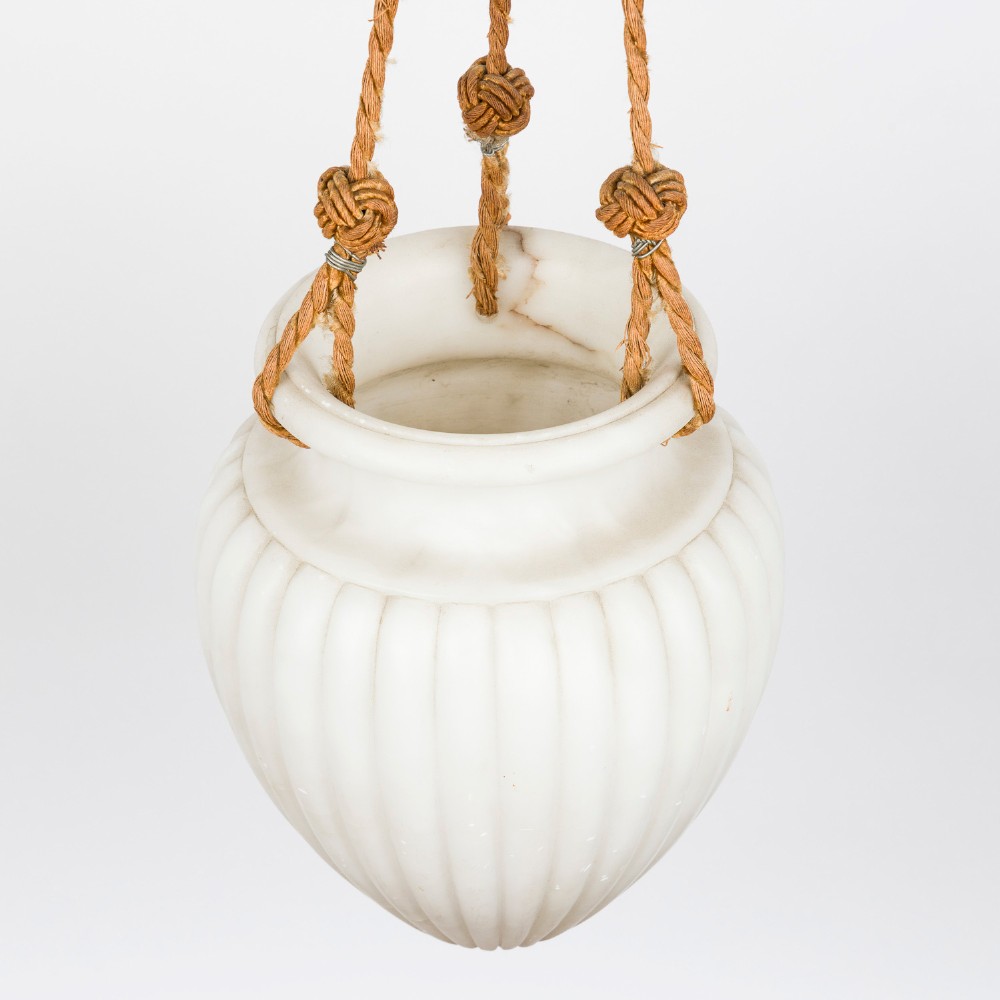 A fluted white alabaster urn-shaped light shade suspended by decorative woven cords and tassels from a matching alabaster ceiling rose. View III
