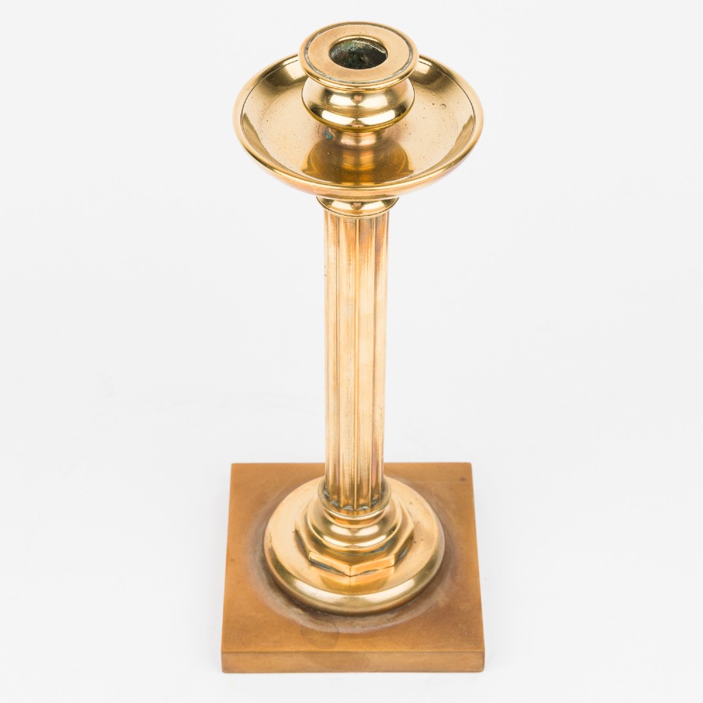 A pair of polished bronze Art Deco candlesticks featuring fluted vertical columns and stepped square plinth bases. View III