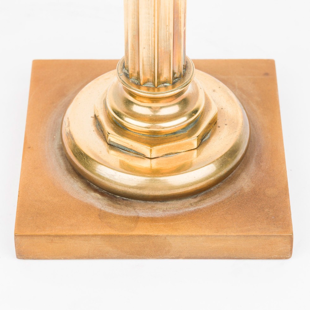 A pair of polished bronze Art Deco candlesticks featuring fluted vertical columns and stepped square plinth bases. View IV
