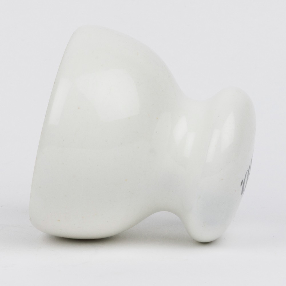 A white glazed ceramic four pound scale weight with black lettering reading Imperial 4 lb printed on top. View IV