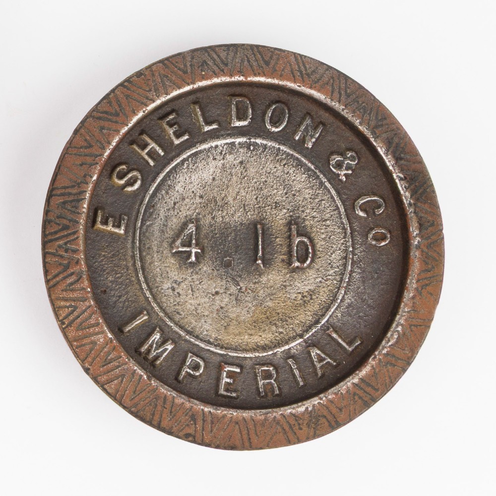 A set of six graduated cast iron nested imperial scale weights stacked into a pyramid shape, featuring textured chevron banding along the sides. View VI