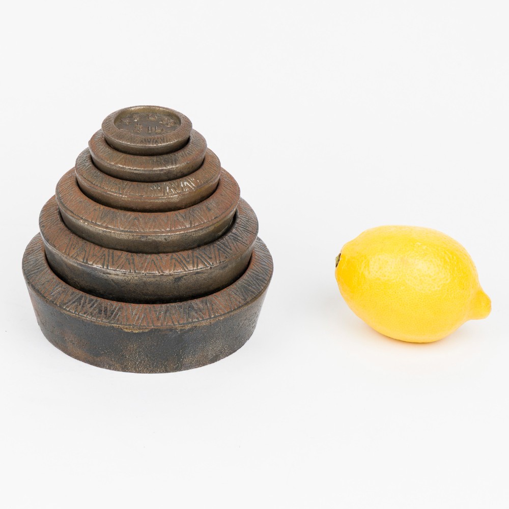 A set of six graduated cast iron nested imperial scale weights stacked into a pyramid shape, featuring textured chevron banding along the sides. View VIII