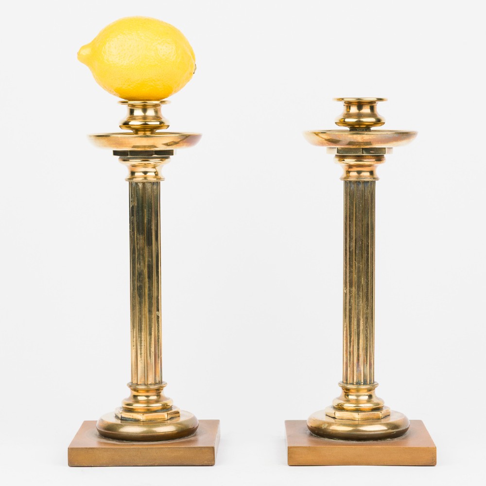 A pair of gilt bronze column candlesticks featuring fluted stems, wide circular drip trays, and square bases. View VI