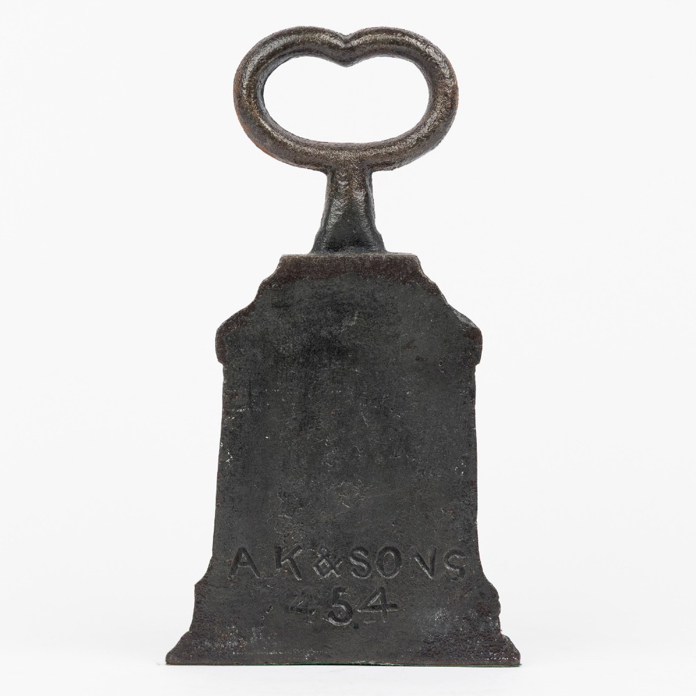 A Victorian cast iron door porter with a bell-shaped body and a heart-shaped loop handle at the top. View IV