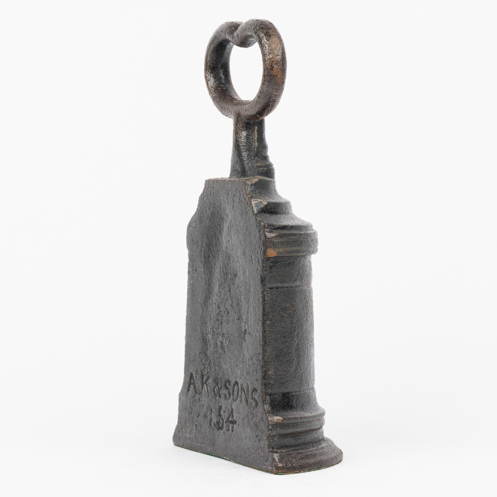 A Victorian cast iron door porter with a bell-shaped body and a heart-shaped loop handle at the top. View VI