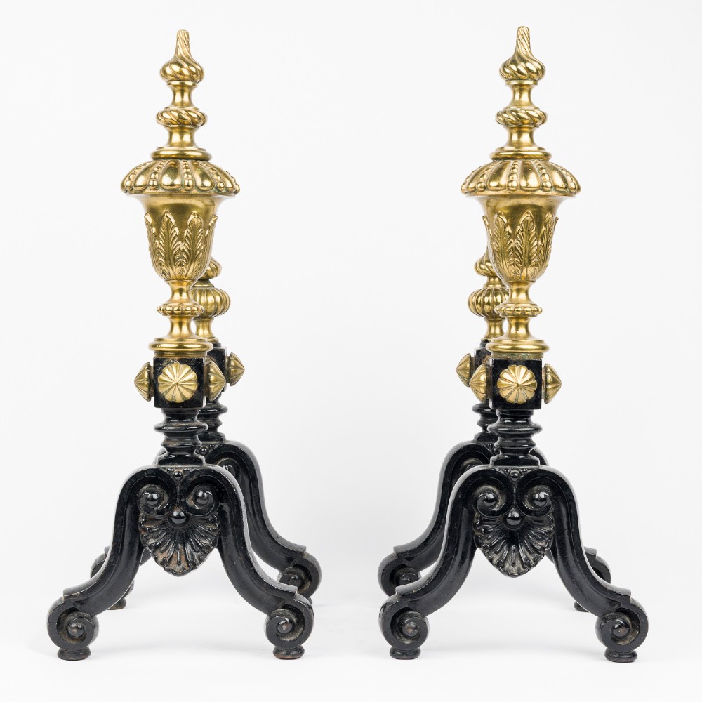 A pair of cast iron and brass fire dogs with ornate brass urn finials, fluted central bars, and black scroll feet. View II
