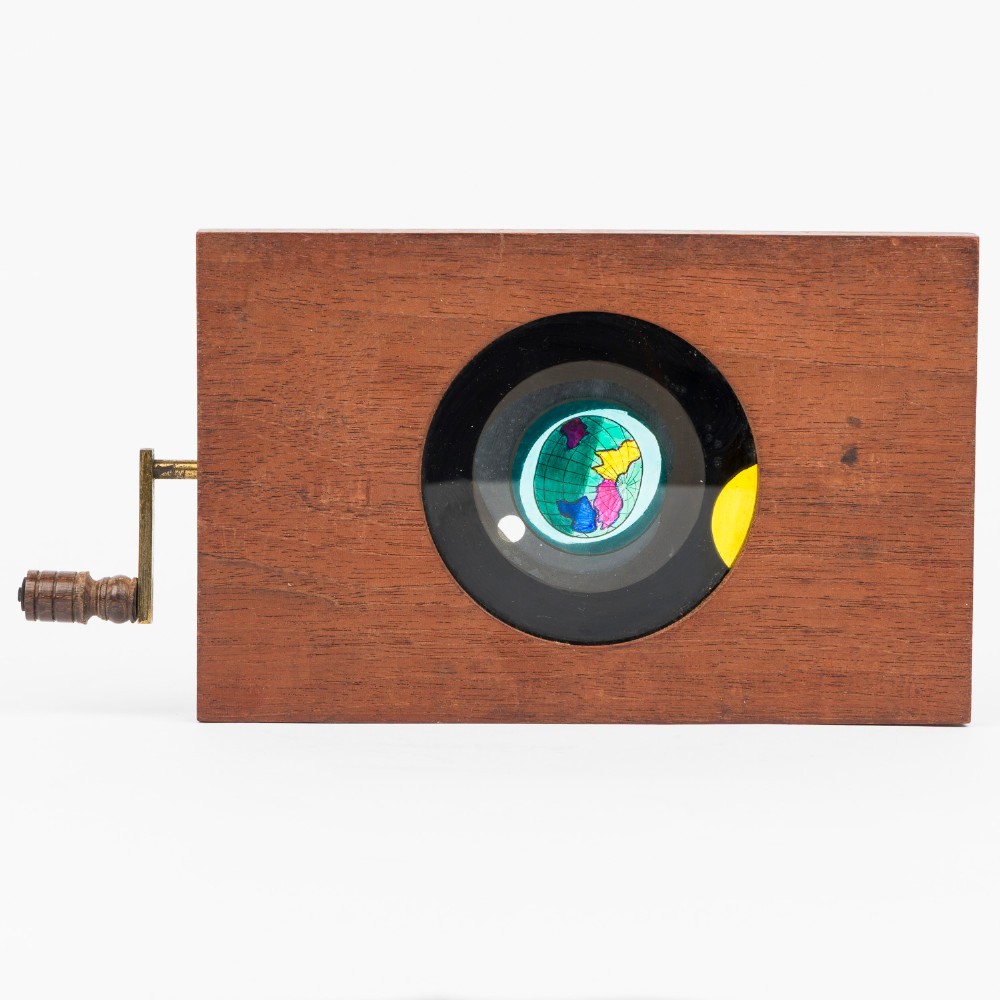 A pair of rectangular mahogany-framed mechanical magic lantern slides featuring hand-coloured astronomical glass apertures and brass hand cranks. View IV