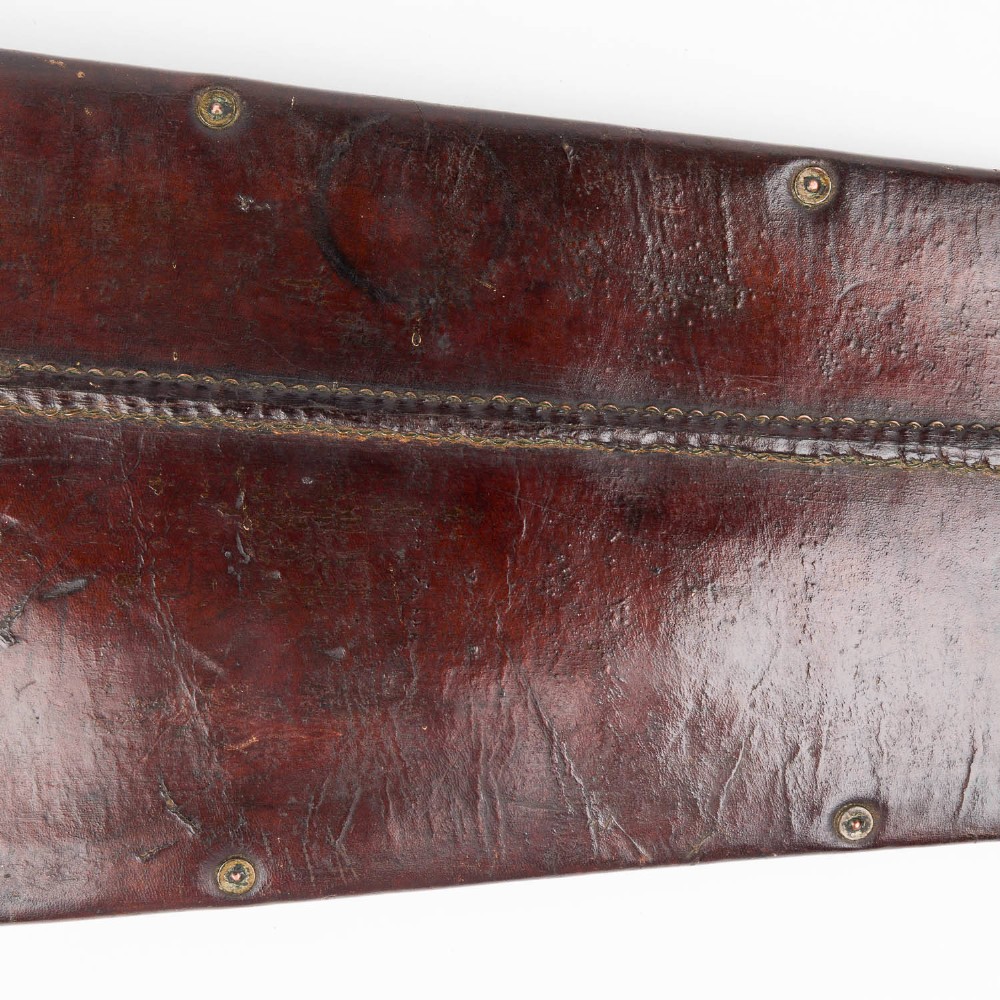 An antique steel hand saw featuring a patinated blade with visible teeth and a shaped wooden handle secured with metal rivets. View VII